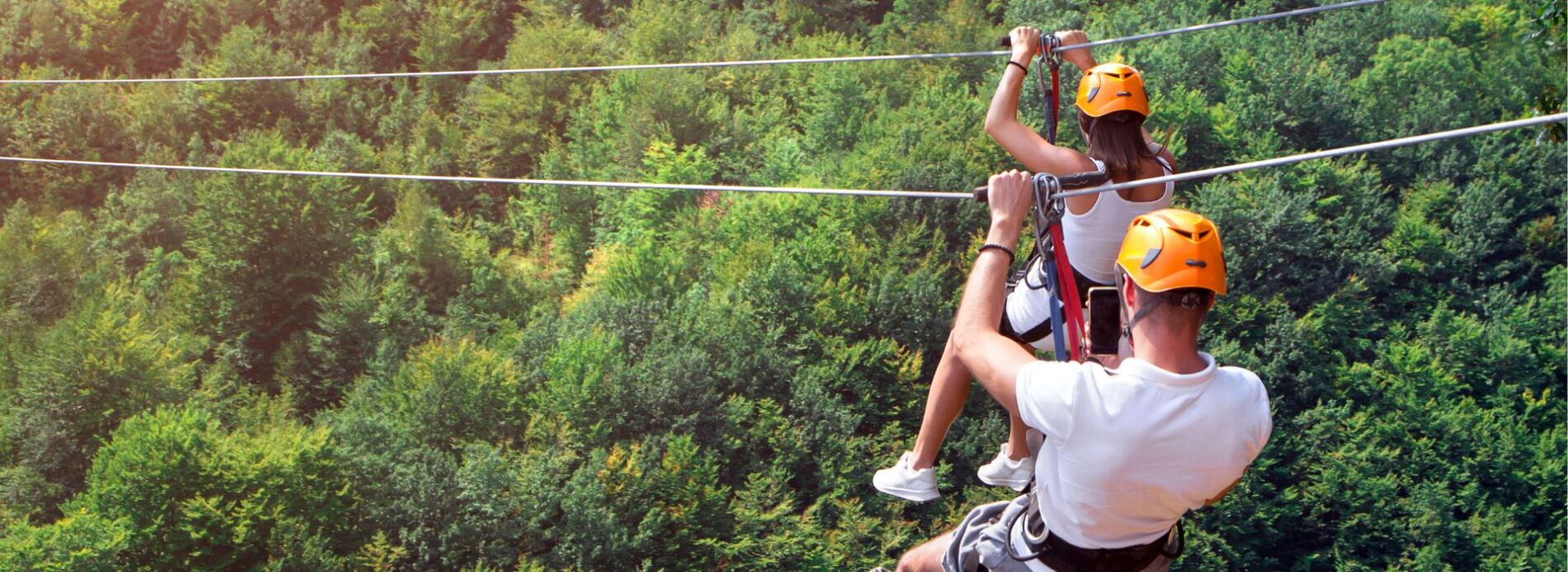 Young people ziplining in forest